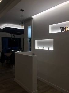 Salle plongée dans le noir pour mettre en valeur les éclairages du plafond et du mur