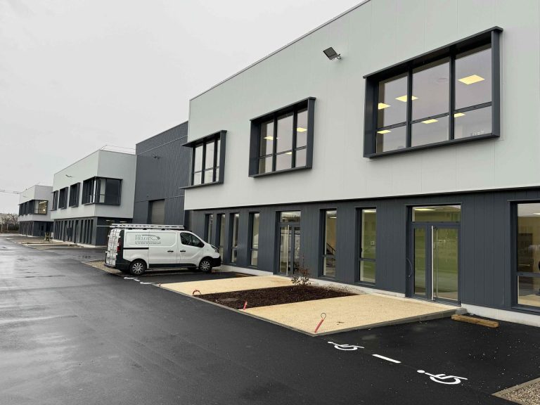 Façade de Bâtiment construite avec un véhicule Helgen stationner devant.
